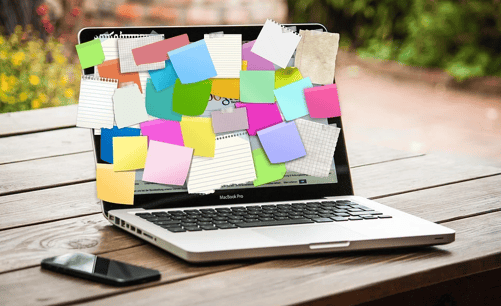 a laptop full of sticky note representing to-do list and scheduling
