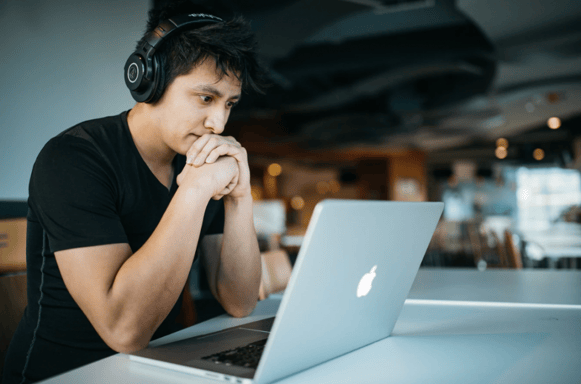 boy working on computer with the headphones on