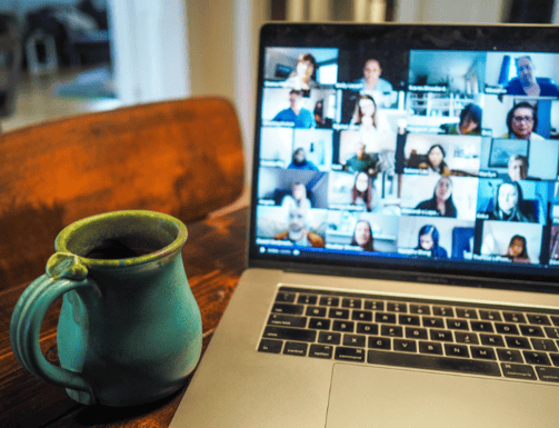Online meeting laptop screen next to coffee cup
